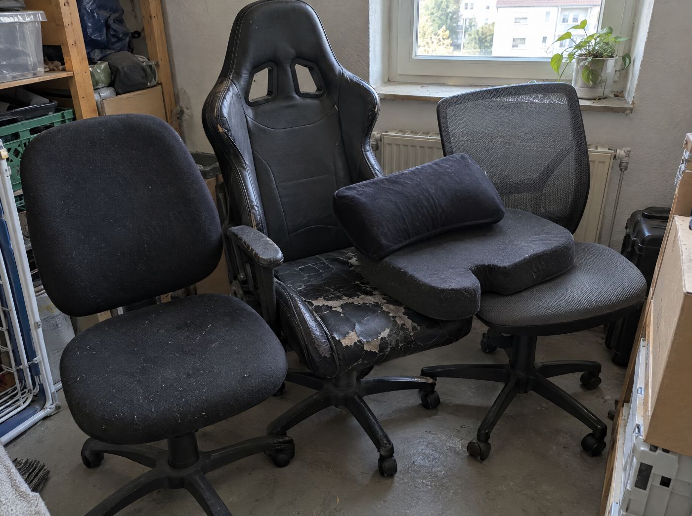 Drei ausrangierte Bürostühle und Sitzkissen im Keller